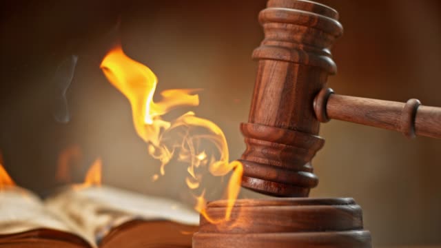 SLO MO LD Judge's gavel striking a burning wooden sound block