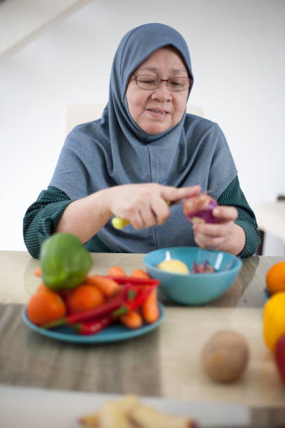 Elderly Malay woman preparing food ingredients