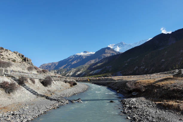 istock Suspension bridge over the river in the Nepalese Himalayas 956500510
