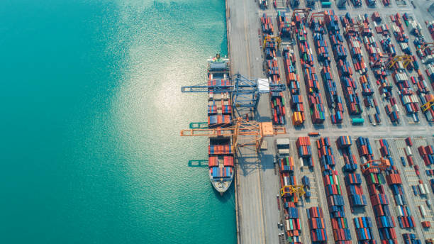 istock Container ship in export and import business and logistics. Shipping cargo to harbor by crane. Water transport International. Aerial view and top view 956500692