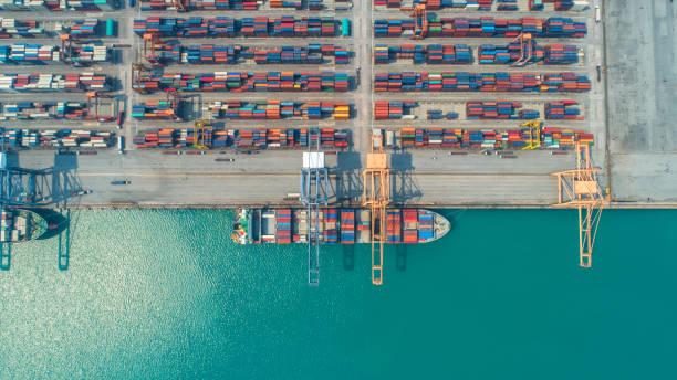 istock Container ship in export and import business and logistics. Shipping cargo to harbor by crane. Water transport International. Aerial view and top view 956500710