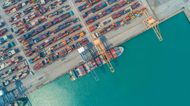 istock Container ship in export and import business and logistics. Shipping cargo to harbor by crane. Water transport International. Aerial view and top view 956500720