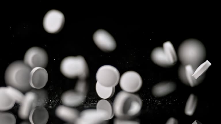 SLO MO LD White tablets falling on black background