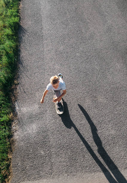 istock Boy skates on skateboard on asphalt road 956514976