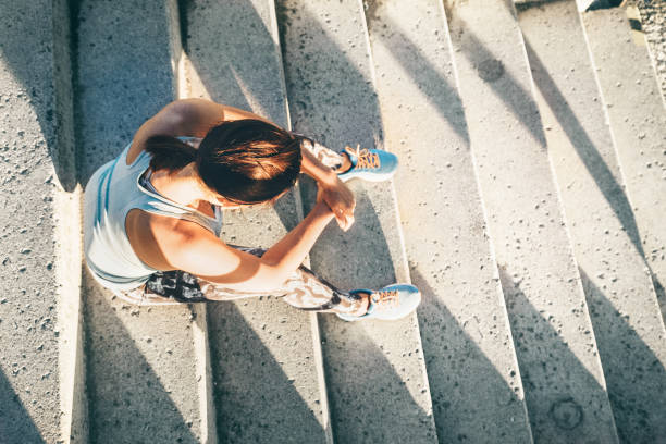 woman rests on stairs after workout set - running athlete staircase teenager imagens e fotografias de stock