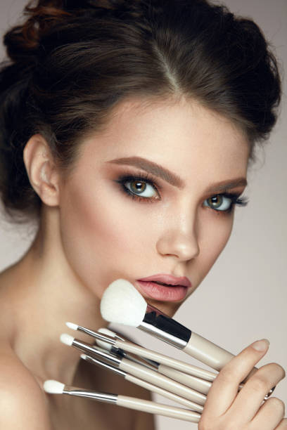 istock Makeup Cosmetics. Glamorous Beautiful Woman Holding Brushes 956517824