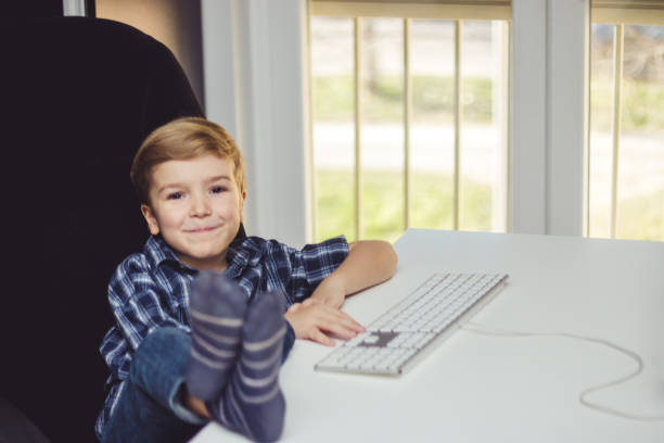 istock Happy kid enjoying in the office with feet up on the table. 956520438