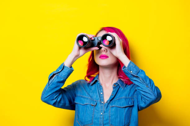 istock girl in blue shirt holding a binoculars. 956521526