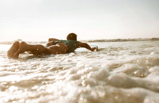 istock Surfer woman floating on long board 956527260