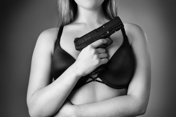 istock woman holding gun 956531786