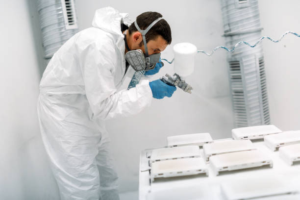 istock Painter using airbrush to paint wearing protective clothing 956533668