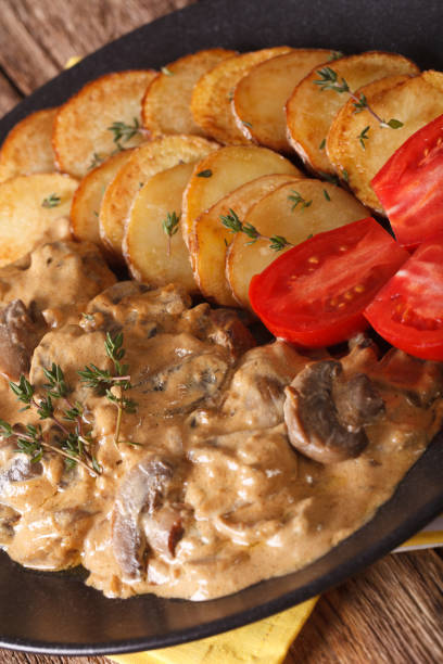 Diana steak garnished with fried potatoes close-up. vertical