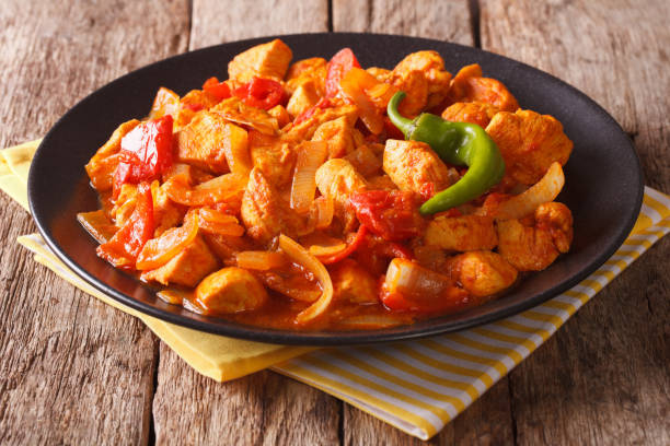istock Indian Cuisine: Spicy chicken jalfrezi with pepper and onion close-up. horizontal 956544310