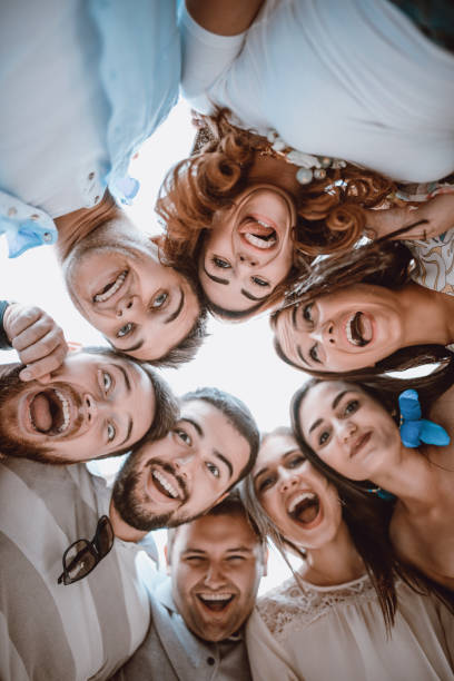 istock Group of Smiling Friends Creating Circle and Looking Down 956555806