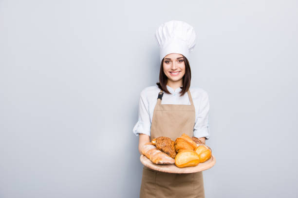 Industry prepare organic natural dough tasty fresh white clothes professional. Portrait of cheerful kind delightful baker demonstrating wooden tray with appetizing food isolated on gray background Industry prepare organic natural dough tasty fresh white clothes professional. Portrait of cheerful kind delightful baker demonstrating wooden tray with appetizing food isolated on gray background delightful stock pictures, royalty-free photos & images