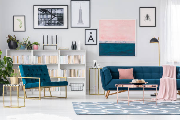 Apartment interior Luxurious apartment interior with blue armchair, sofa and carpet with bookshelf in the background metal molding stock pictures, royalty-free photos & images