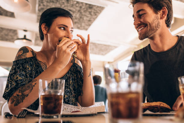 istock Couple at restaurant having burger 956559466