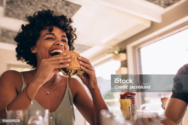 レストランでハンバーガーを食べることを楽しむ女性 - 食べるのストックフォトや画像を多数ご用意 - 食べる, ハンバーグ料理, レストラン
