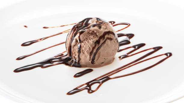 istock Chocolate ice cream ball decorated with chocolate syrup on a white plate 956560846