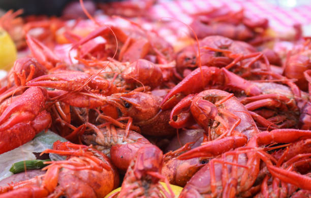 istock Crawfish boil - cooked seafood and vegetables piled on a red and white checked tablecloth 956564214