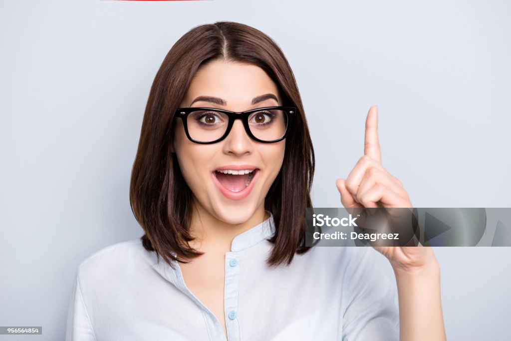 Nahaufnahme Portrait hübsche, charmante, froh, dass Frau in t-shirt, Brillen, die Suche nach einer Idee, die Auflösung, die Zeigefinger zeigen mit offenem Mund, auf grauem Hintergrund isoliert - Lizenzfrei Frauen Stock-Foto