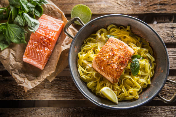 Pieces of roasted salmon with pasta tagliatelle lemon and basil.