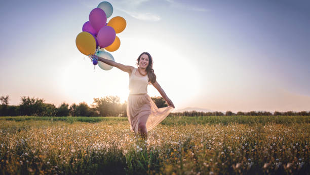 istock Smiling girl running with balloons 956576826
