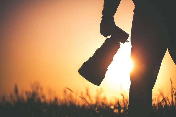 Outdoor Wildlife Photographer Safari Outdoor Photographer at Sunset. Silhouette of Men Keeping Digital Camera in Hand with Large Telephoto Lens For the Better Wildlife Closeups. telephoto lens stock pictures, royalty-free photos & images