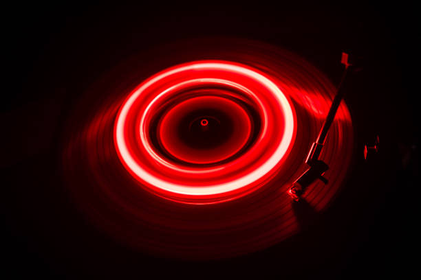 istock Turntable playing vinyl with glowing abstract lines concept on dark background 956587762