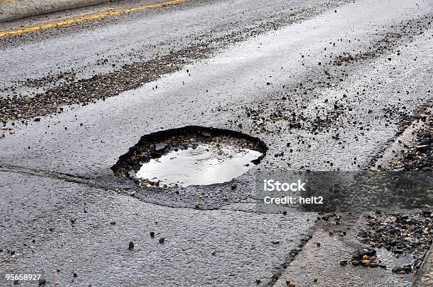A Large Pot Hole Filled With Water On An Asphalt Road Stock Photo - Download Image Now