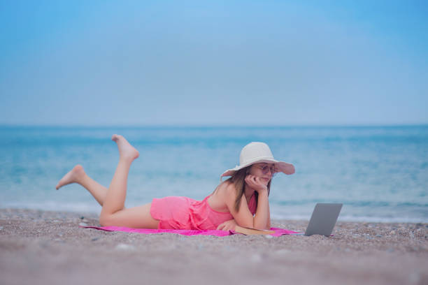 istock young business woman on vacation reading mail 956596474
