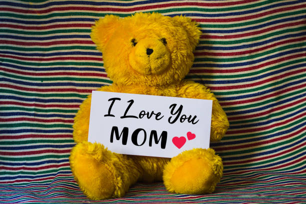 istock Yellow teddy bear holding a white card with lettering I LOVE DADDY 956609500