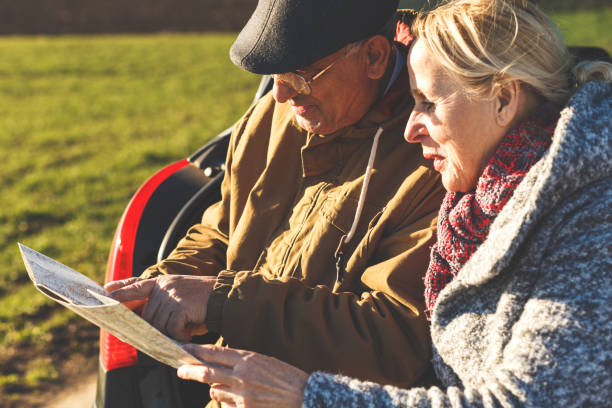 istock Happy senior couple on a road trip, they are using map for direction. 956609952