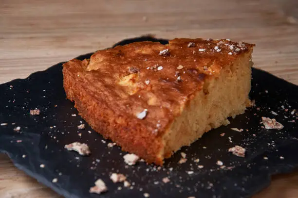 Photo of A piece of apple pie with grated chocolate near chocolate truffle candies. Selective focus and small depth of field.