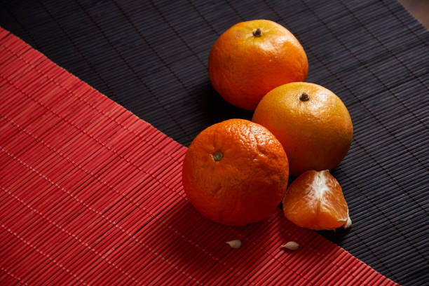 istock Tangerines in plate on black and red background 956610390