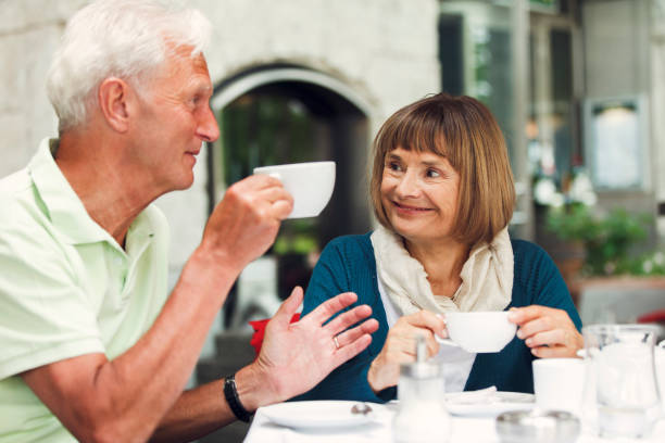 istock Senior Couple Drinking Coffee In Cafe 956614092