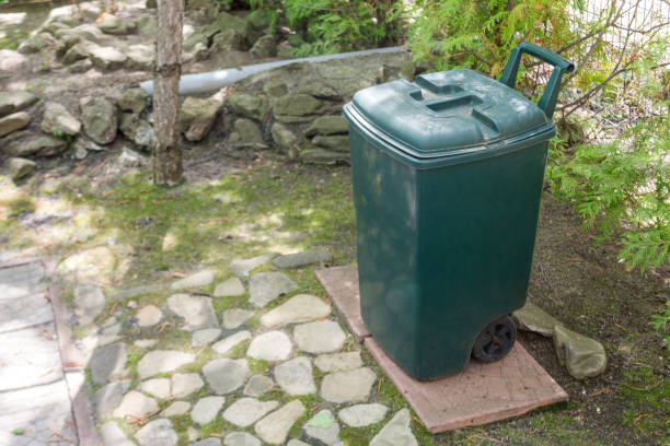 istock Green plastic garbge bin in garden.Single garbage container stand in park 956622902