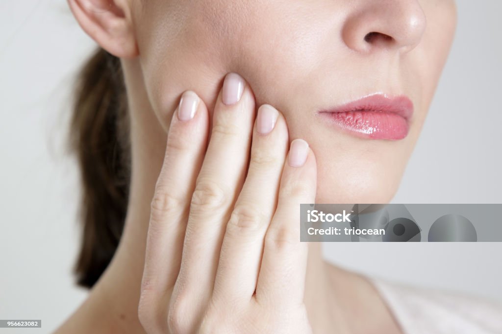 Studio shot of young woman with tooth pain, close up Pain Stock Photo
