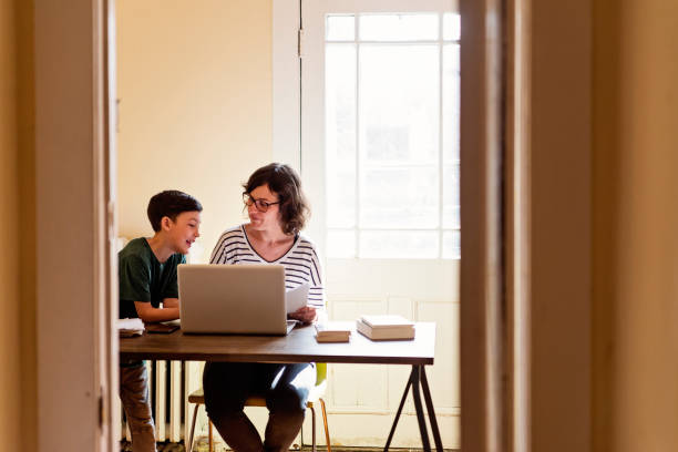 istock Single mother working from home with preteen son. 956630342