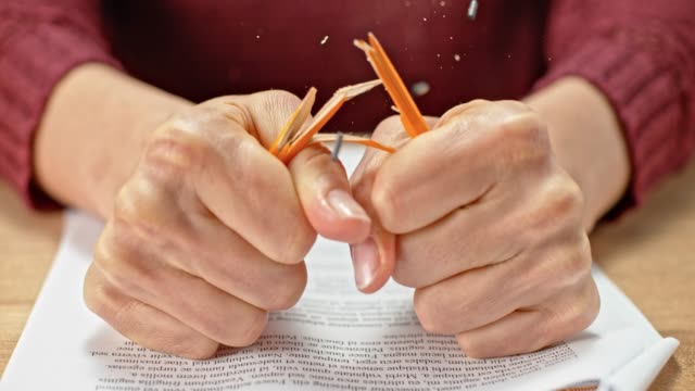 SLO MO LD Hands of a young woman breaking a pencil