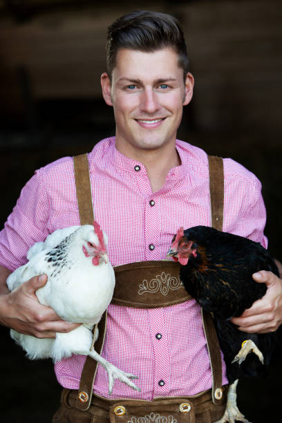 istock young bavarian man holding two chickens 956642536
