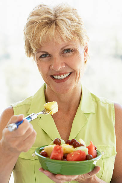 istock Middle Aged Woman Eating Fresh Fruit Salad 95664374