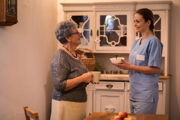 istock Senior women talking with young nurse standing in kitchen 956643854