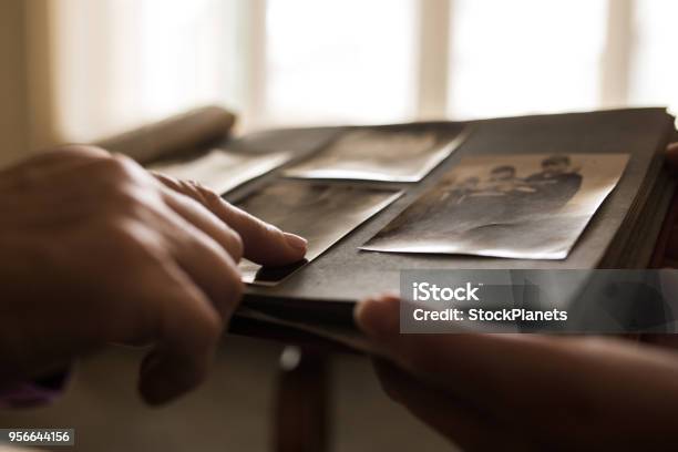 Close Up Human Hand Pointing To Photo In Photo Album Stock Photo - Download Image Now