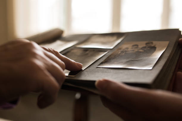 fechar a mão humana, apontando para uma foto no álbum de fotos - nostalgia - fotografias e filmes do acervo