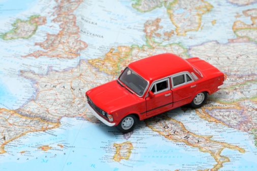 Tiny red car model on the map of Europe