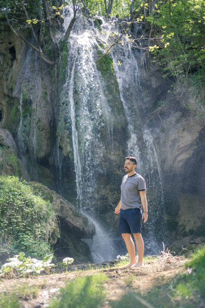 istock young man in front of waterfall 956657694