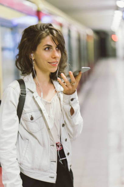 istock Young woman using smartphone at the subway station 956662396
