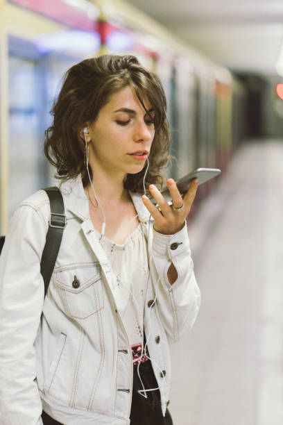 istock Young woman using smartphone at the subway station 956662468