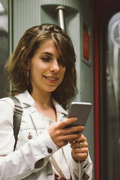 istock Young woman using smartphone on the subway train 956662886